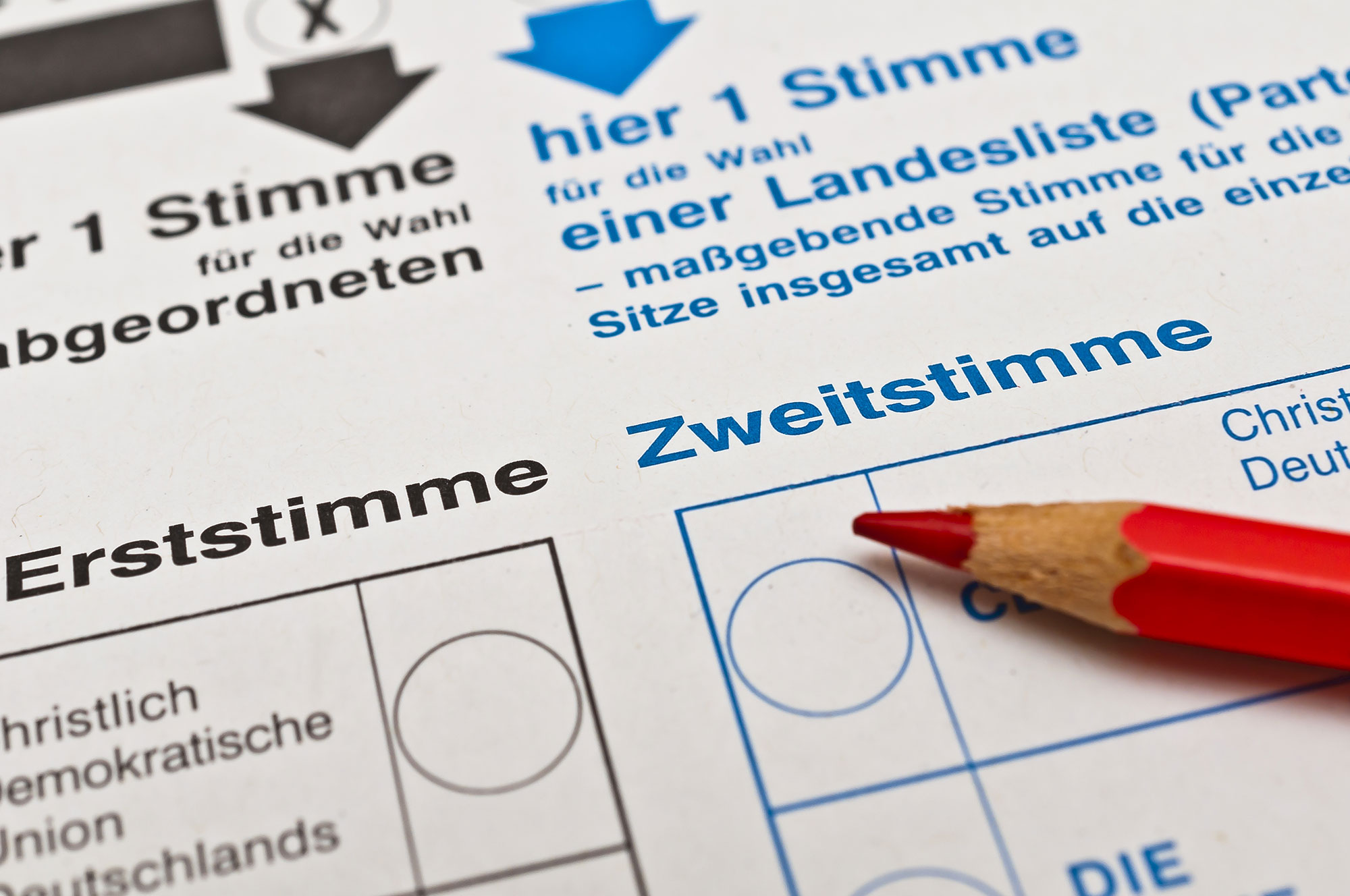 Das Foto zeigt einen Bundestagswahlzettel, auf dem ein roter Buntstift liegt.