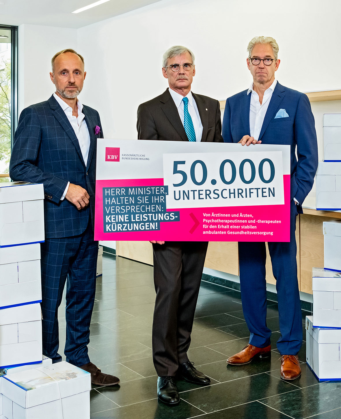 Das Foto zeigt die KBV-Vorstände Dr. Andreas Gassen, Dr. Thomas Kriedel und Dr. Stephan Hofmeister mit der symbolischen Präsentation der Zahl von 50.000 Unterschriften.