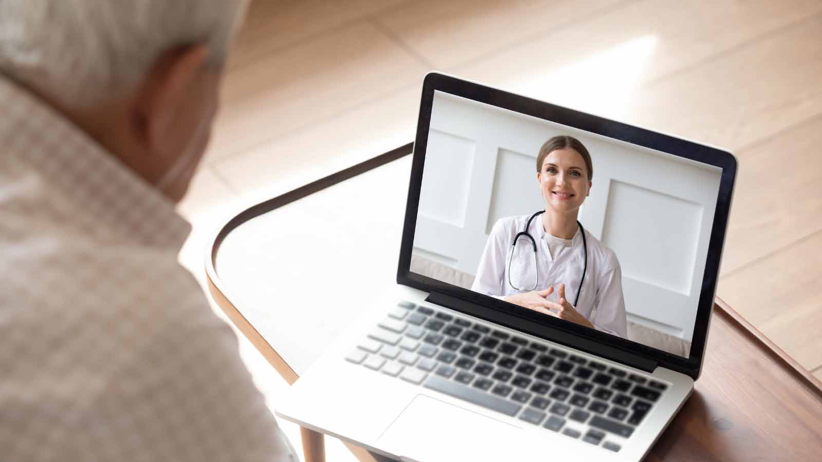 Das Titelfoto zeigt einen Patienten bei einer Videosprechstunde mit einer Ärztin.
