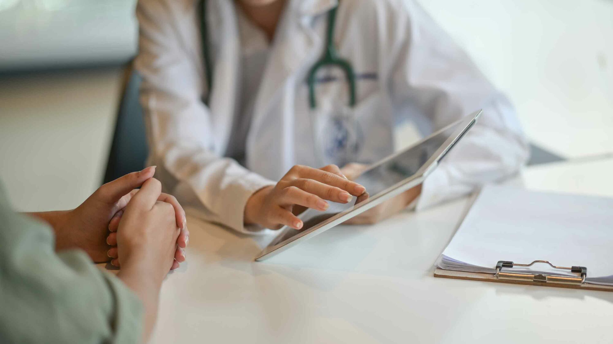 Das Foto zeigt eine Ärztin, die einer Patientien etwas auf einem Tablett-PC zeigt.