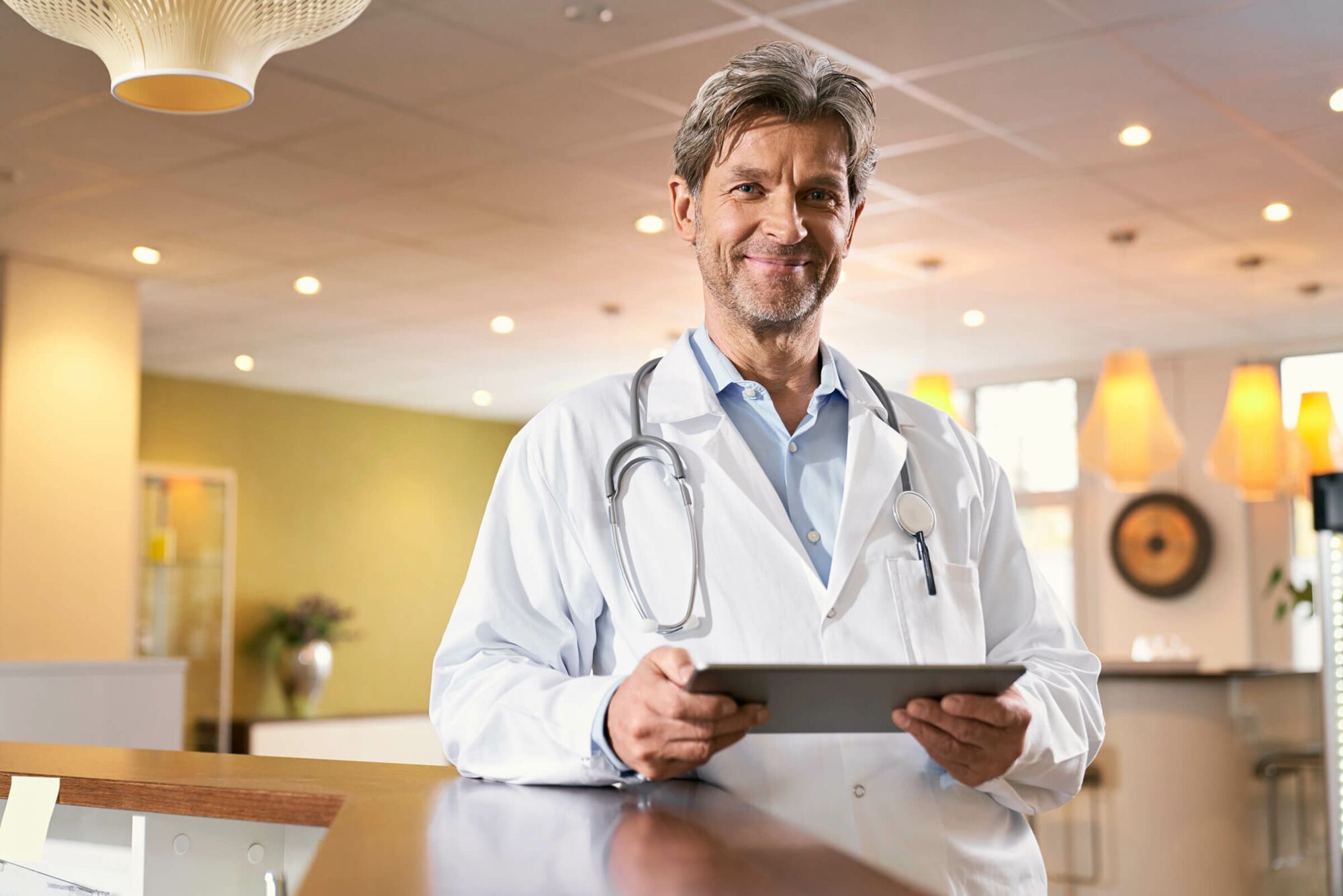 Das Foto zeigt einen Arzt, der ein Tablet-PC in der Hand hält.
